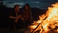 Lovely campers relax bonfire in night mountains. Family feel happy in nature.