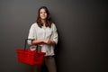 Lovely casual girl going to store holding empty shapping basket