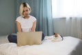 Lovely cat sleeping on office files on a desktop, a woman is sitting at desk and working with a laptop Royalty Free Stock Photo