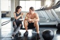 Lovely caucasian couple fitness man and woman take a rest and eating salad in gym after finish fitness training with happy smiling Royalty Free Stock Photo