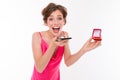 Lovely caucasian girl with a box with a ring in her hands calls on a telon and reports joy on a white background