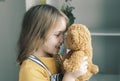 Lovely caucasian girl holding kissing teddy bear,child with toy,smiling happy kid portrait indoors.Happy childhood Royalty Free Stock Photo