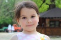 Lovely cheerful smiling little girl with a tail in a sundress on the river bank Royalty Free Stock Photo