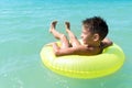 Lovely child boy swimming in inflatable ring in blue water