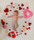 Lovely child. Small girl among red hearts. Love. Portrait of happy little child. Sweet little baby. New life and birth Royalty Free Stock Photo