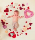 Lovely child. Small girl among red hearts. Love. Portrait of happy little child. Sweet little baby. New life and birth Royalty Free Stock Photo