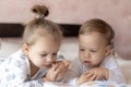 Lovely children - brother and sister, reading a book, on the bed. Close up of children in bed reading a book. A boy and Royalty Free Stock Photo