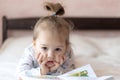 Lovely children - brother and sister, reading a book, on the bed. Close up of children in bed reading a book. A boy and Royalty Free Stock Photo