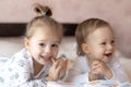 Lovely children - brother and sister, reading a book, on the bed. Close up of children in bed reading a book. A boy and Royalty Free Stock Photo