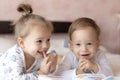 Lovely children - brother and sister, reading a book, on the bed. Close up of children in bed reading a book. A boy and Royalty Free Stock Photo