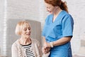 Lovely competent nurse supporting elderly lady