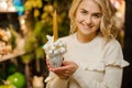 Lovely composition in pot of white Christmas balls and golden candle in hands of woman Royalty Free Stock Photo