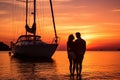Lovely couple admiring sunset sitting on yacht deck while sailing in the sea. Handsome man and beautiful woman having romantic Royalty Free Stock Photo