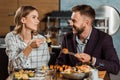 Lovely couple amorously looking at each other and eating sushi rolls