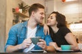 Lovely couple beautiful woman and handsome man drinking hot coffee in the cafe having romantic date hugging looking happy Royalty Free Stock Photo