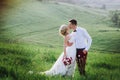 Lovely couple, bride and groom posing in field during sunset, lifestyle Royalty Free Stock Photo