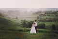 Lovely couple, bride and groom posing in field during sunset, lifestyle Royalty Free Stock Photo