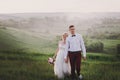 Lovely couple, bride and groom posing in field during sunset, lifestyle Royalty Free Stock Photo