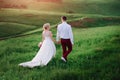 Lovely couple, bride and groom posing in field during sunset, lifestyle Royalty Free Stock Photo