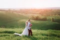 Lovely couple, bride and groom posing in field during sunset, lifestyle Royalty Free Stock Photo