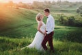 Lovely couple, bride and groom posing in field during sunset, lifestyle Royalty Free Stock Photo