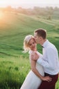 Lovely couple, bride and groom posing in field during sunset, lifestyle Royalty Free Stock Photo