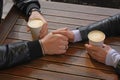 Lovely couple with coffee holding hands together at wooden table, closeup. Romantic date Royalty Free Stock Photo