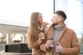 Lovely couple with cups of coffee on street in morning Royalty Free Stock Photo