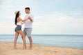 Lovely couple dancing on beach near sea. Space for text Royalty Free Stock Photo