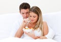 Lovely couple eating fruit salad in bed Royalty Free Stock Photo