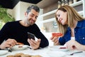 Lovely couple having breakfast and looking photos in mobile phone in the kitchen at home Royalty Free Stock Photo