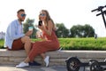 Lovely couple having fun driving electric scooter through the city, having a break, drinking coffee Royalty Free Stock Photo