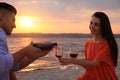 Lovely couple having picnic near river at sunset Royalty Free Stock Photo