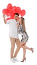 Lovely couple with heart shaped balloons taking selfie on white background. Valentine`s day celebration