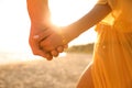 Lovely couple holding hands on beach at sunset, closeup Royalty Free Stock Photo