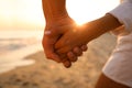Lovely couple holding hands on beach at sunset Royalty Free Stock Photo