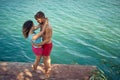 Lovely couple hugging. Young man and woman standing by water on wooden jetty. Summertime vacation. Togetherness, love, holiday,