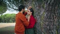 Lovely couple kissing park leaning at tree closeup. Family pair standing hugging Royalty Free Stock Photo