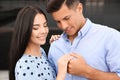 Lovely couple looking at beautiful engagement ring outdoors