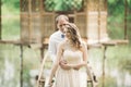 Lovely couple in love kissing each other on the day wedding, standing in the park outdoors near lake