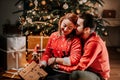 Lovely couple in love opening christmas presents. Together for christmas, holiday joy and happyiness concept