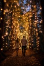 A lovely couple of lovers holding hands & walking on cosmic pathways in a fantasy magical glowing enchanted forest. AI generated.