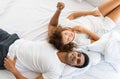 Lovely couple lying, talking, on white blanket  in bedroom. Relation in family. Relaxing in the morning Royalty Free Stock Photo