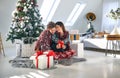 A lovely couple in romantic moments at home while opening Xmas presents together. Christmas, relationship, love