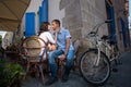 Lovely couple sitting in sidewalk cafe near their tandem bicycle Royalty Free Stock Photo