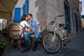 Lovely couple sitting in sidewalk cafe near their tandem bicycle Royalty Free Stock Photo