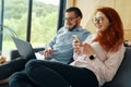 Lovely couple spending time together at home, using laptop and smartphone Royalty Free Stock Photo