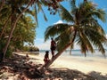 Lovely couple standing near palm trees in paradise Onok Island in Balabac Palawan in Philippines