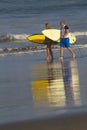 Lovely couple with surfboards on beach. Royalty Free Stock Photo