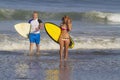 Lovely couple with surfboards on beach. Royalty Free Stock Photo